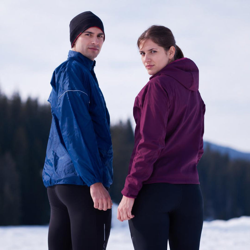 Couple standing in winter landscape wearing professional outdoor hiking gear