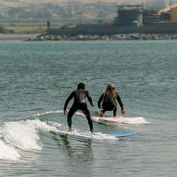 Two surfers balancing on surfboards while riding ocean waves together